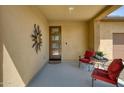 Cozy covered front porch with a decorative door, comfortable seating, and modern desert decor at 13204 W Via Dona Rd, Peoria, AZ 85383