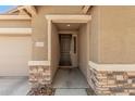 Close-up shot of a front door and the house number, framed by stone accents at 15573 W Laurel Ln, Surprise, AZ 85379