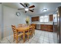 Eat-in kitchen features stainless appliances, wood cabinets, white tile floor, and ceiling fan at 1740 W Crescent Ave, Mesa, AZ 85202