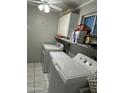 Functional laundry room with washer, dryer, and ample storage space with shelves at 1740 W Crescent Ave, Mesa, AZ 85202