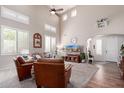 Inviting living room with high ceilings, neutral paint, lots of natural light, and beautiful wood floors at 17538 W Marshall Ln, Surprise, AZ 85388