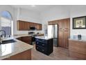 Modern kitchen with stainless steel appliances, granite countertops, and a center island at 18014 N 53Rd Pl, Scottsdale, AZ 85254