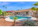 Backyard oasis with a sparkling pool, lounge chairs, and lush greenery with a privacy fence at 18014 N 53Rd Pl, Scottsdale, AZ 85254