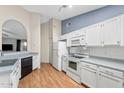 Bright kitchen with white cabinetry, appliances, and ample counter space, complemented by wood-look flooring at 1836 N Stapley Dr # 4, Mesa, AZ 85203