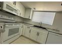 Updated kitchen featuring white cabinets, modern appliances, stainless steel sink, and tile flooring at 225 N Pomeroy -- # 16, Mesa, AZ 85201