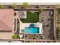 A luxurious backyard oasis with a sparkling pool, spa, pergola, and pristine artificial turf at 31106 N 130Th Ln, Peoria, AZ 85383