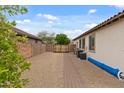 Spacious backyard featuring a mix of gravel and brick accents with a gate for added privacy and security at 31106 N 130Th Ln, Peoria, AZ 85383
