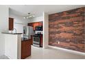 Open kitchen featuring stainless steel appliances and contrasting brick accent wall, with updated countertops at 3302 N 7Th St # 211, Phoenix, AZ 85014