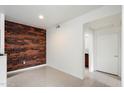 Modern living space with a distinctive brick accent wall, complemented by sleek flooring and lighting at 3302 N 7Th St # 211, Phoenix, AZ 85014