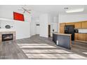 Spacious living room with a fireplace, a bar area, and luxury vinyl flooring at 4031 E Barwick Dr, Cave Creek, AZ 85331