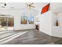 Bright living room with vaulted ceilings, luxury vinyl flooring, a fireplace, and access to the backyard at 4031 E Barwick Dr, Cave Creek, AZ 85331