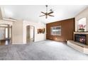 Open-concept living space with fireplace, neutral paint scheme, plush carpet, and view into the kitchen at 450 E Duke Dr, Casa Grande, AZ 85122