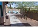 Relaxing backyard with comfortable seating, paver stones, desert landscaping, and mature trees for shade at 5013 E Shomi St, Phoenix, AZ 85044