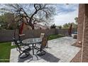 Inviting backyard patio featuring a paver patio, artificial turf, and an outdoor dining set for entertaining at 5013 E Shomi St, Phoenix, AZ 85044