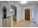 Inviting foyer with wood-look flooring, coat closet, stylish entry door, and convenient pass-through to the kitchen at 614 W Kings Ave, Phoenix, AZ 85023