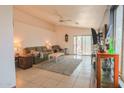 Bright living room featuring tiled flooring, neutral walls, a ceiling fan, and sliding glass doors to the patio at 7915 N 53Rd Dr, Glendale, AZ 85301