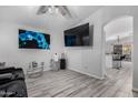 Bright living room featuring modern flooring, neutral walls, and contemporary decor with a large TV at 8741 W Manzanita Dr, Peoria, AZ 85345
