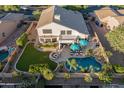 An aerial shot showing a backyard featuring a pool, patio with seating, lush lawn and mature landscaping at 9443 E Mallory St, Mesa, AZ 85207