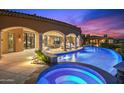 Outdoor entertainment space featuring a pool and spa with colorful lights on a desert evening at 9643 E Legacy Ridge Rd, Scottsdale, AZ 85262