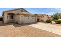 Beige single-story home featuring a two-car garage and low-maintenance gravel landscaping at 9733 W Purdue Ave, Peoria, AZ 85345