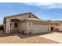 Beige single-story home featuring a two-car garage and low-maintenance gravel landscaping at 9733 W Purdue Ave, Peoria, AZ 85345