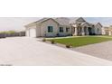 Spacious home with a long driveway and a manicured front yard providing a welcoming first impression at 1244 N 106Th Pl, Mesa, AZ 85207
