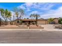 Inviting single story home featuring desert landscaping, a two-car garage, and a covered front porch at 1403 W Wood Dr, Phoenix, AZ 85029