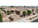 Aerial view showcases the property's charming desert landscaping, brick driveway, and well-maintained surroundings at 14390 W Desert Flower Dr, Goodyear, AZ 85395