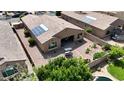 Aerial view showcases a backyard with desert landscaping and a cozy patio with a swing, plus a pool nearby at 14390 W Desert Flower Dr, Goodyear, AZ 85395