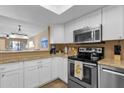 Bright kitchen featuring white cabinets, granite countertops, and stainless steel appliances at 16739 E El Lago Blvd # 103, Fountain Hills, AZ 85268