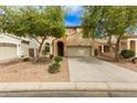 Beautiful exterior of home featuring a two-car garage and desert landscaping at 17507 N Costa Brava Ave, Maricopa, AZ 85139