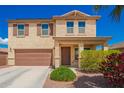 Inviting two-story home featuring a desert landscape, complemented by a neat lawn, and a two-car garage at 18318 W Pueblo Ave, Goodyear, AZ 85338