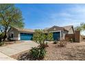 An exterior view of a desert home featuring a three-car garage and drought-resistant landscaping at 23063 W Loma Linda Blvd, Buckeye, AZ 85326