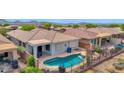 Inviting backyard pool with desert landscaping and mountain views provides a relaxing retreat at 2452 W Muirfield Dr, Anthem, AZ 85086
