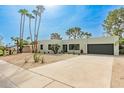 Modern home with desert landscaping, tall palm trees, and a sleek, minimalist design at 2517 E Sahuaro Dr, Phoenix, AZ 85028