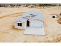 New home with a modern design, neutral colors, a two-car garage, and a concrete driveway at 25745 W Peak View Rd, Wittmann, AZ 85361