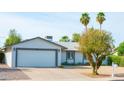 Charming single-story home with desert landscaping, a two-car garage, and mature palm trees at 313 E Westchester Dr, Tempe, AZ 85283