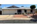 Single-story home with a two-car garage, desert landscaping, and low-maintenance yard at 3242 W Christy Dr, Phoenix, AZ 85029
