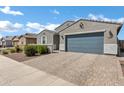 Front exterior view showcases the home's two-car garage, stone driveway, and tidy landscaping at 4140 E Caitlin Dr, San Tan Valley, AZ 85140
