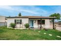 Charming single-story home featuring a bright blue front door and a well-manicured lawn with stepping stones at 4630 N 12Th Pl, Phoenix, AZ 85014