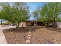 Inviting home with desert landscaping, stepping stone pathway, and mature shade trees at 4810 W Kelton Ln, Glendale, AZ 85306