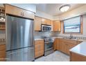 Well-lit kitchen features stainless steel appliances and wood cabinetry at 6721 E Mcdowell Rd # H324, Scottsdale, AZ 85257