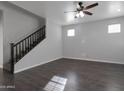Open living room boasts sleek flooring, a ceiling fan, and staircase access to the upper level at 7336 S 48Th Gln, Laveen, AZ 85339