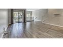 Open living room with wood-look tile flooring, balcony and large windows for natural light at 815 E Rose Ln # 105, Phoenix, AZ 85014