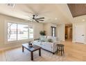 Bright living room featuring a neutral sofa, coffee table, large window, and unique ceiling fan at 8602 E Whitton Ave, Scottsdale, AZ 85251