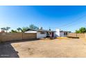 View of backyard with low brick wall and white brick outbuilding under clear blue sky at 1038 E Northern Ave, Phoenix, AZ 85020