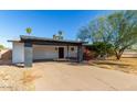 Single-story home featuring a covered carport, red front door, and desert landscaping at 1038 E Northern Ave, Phoenix, AZ 85020