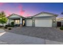 Charming home featuring a well-manicured lawn, stone accents, a covered porch, and a spacious two-car garage at 11656 N San Clemente St, Surprise, AZ 85388