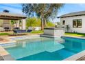 Gorgeous backyard with a pool, spa, outdoor fireplace, lounging area and mature trees at 12633 N 81St St, Scottsdale, AZ 85260