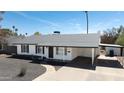 A well-maintained home features a carport, desert landscaping, and white brick exterior under a clear sky at 1633 E Wesleyan E Dr, Tempe, AZ 85282